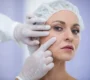 doctor examining female patients face cosmetic treatment min 90x80